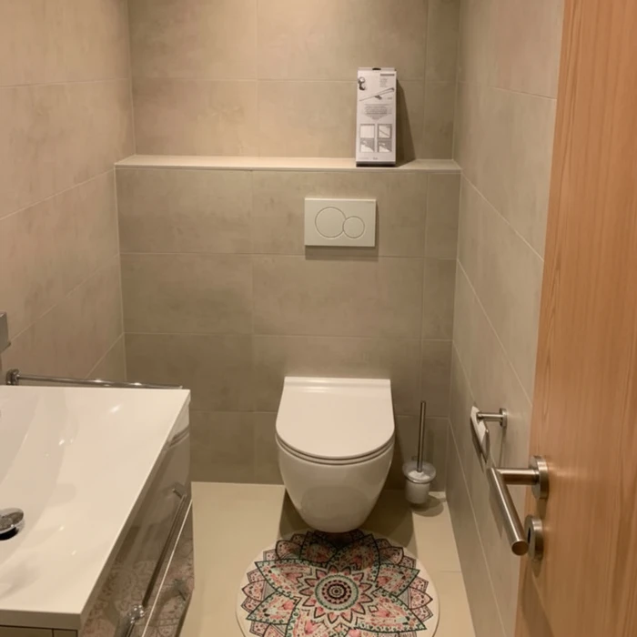 Salle de bain moderne avec WC suspendu blanc et lave-linge intégré sous plan vasque