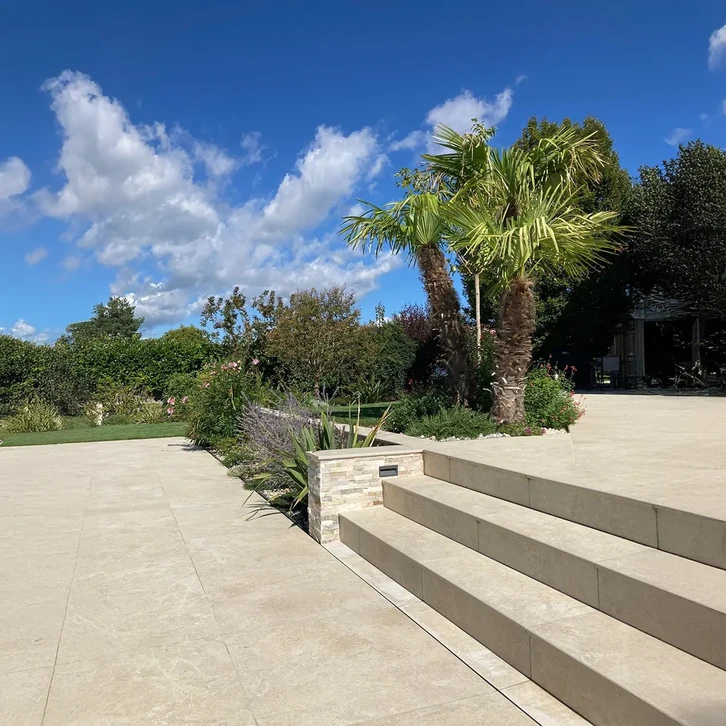 Terrasse moderne d'immeuble avec garde-corps en verre et inox, colonnes blanches architecturales créant un rythme régulier